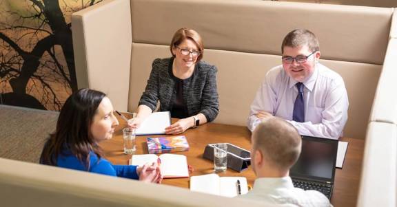 Four colleagues using a meeting booth. 