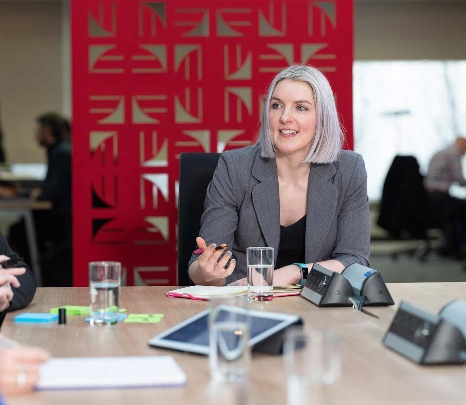 A woman sitting at a boardroom table in a business meeting. 